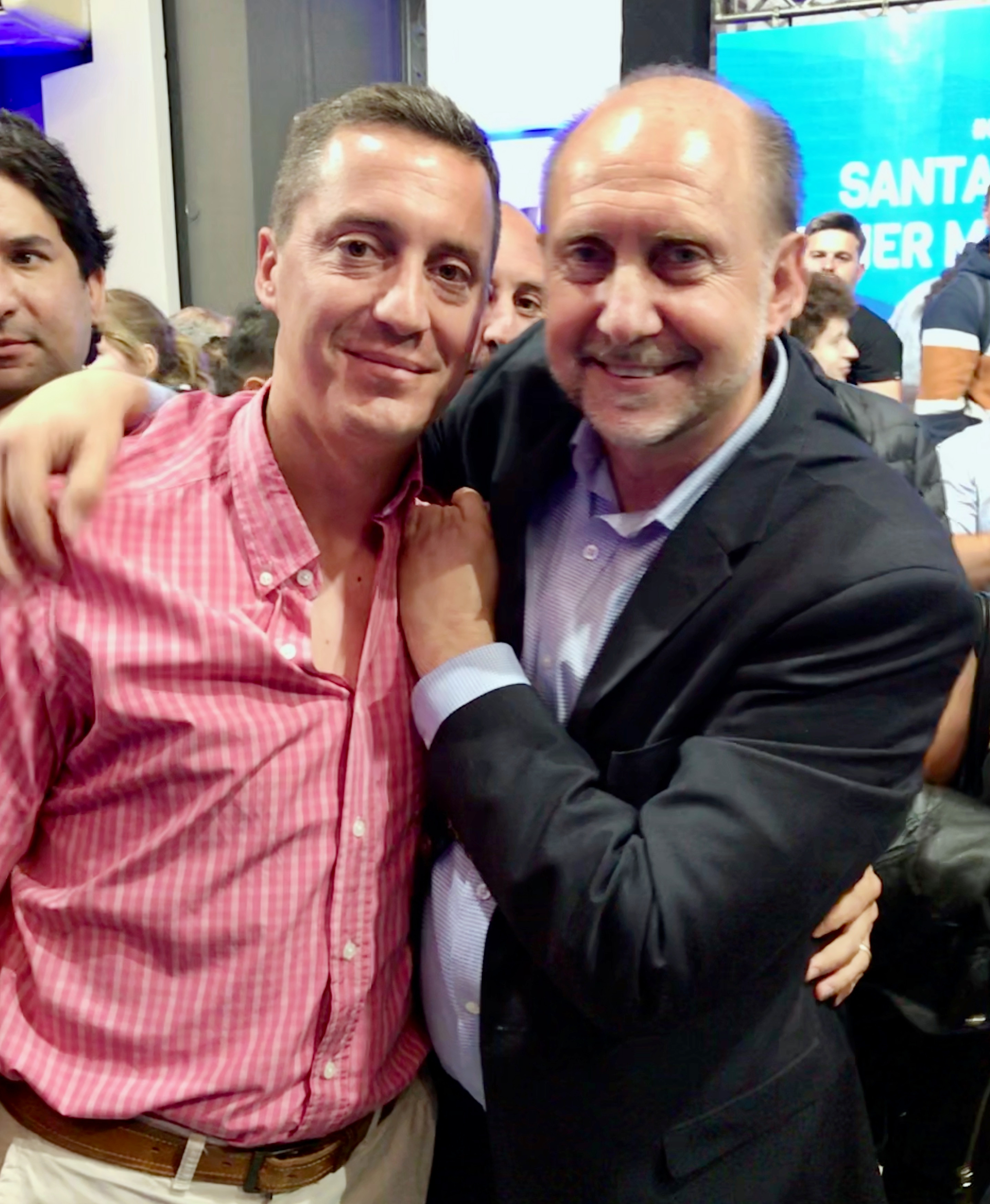 Dos personas abrazadas posan para una fotografía durante un encuentro con público.