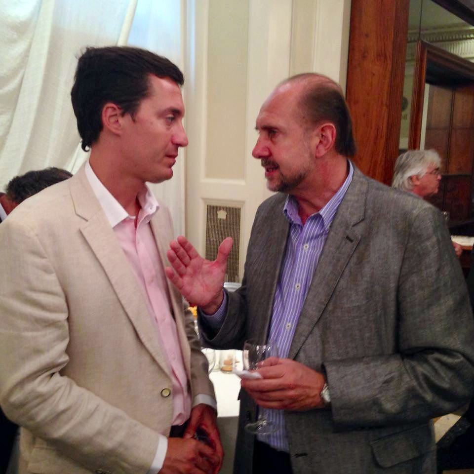 Dos personas conversan durante un encuentro en un salón.