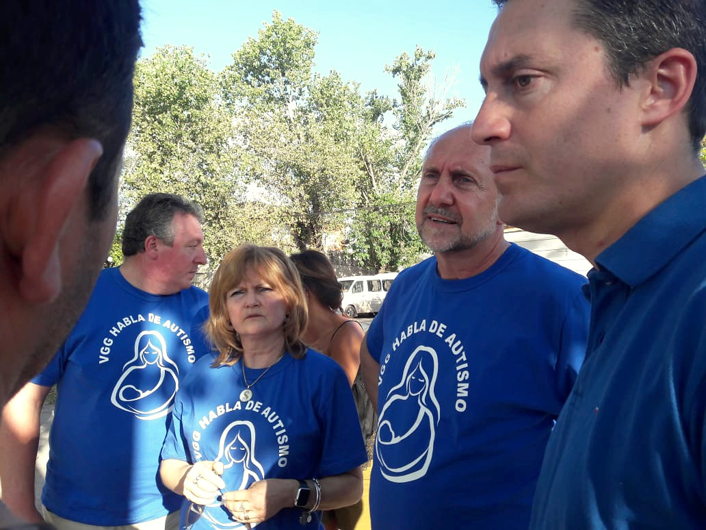 Personas reunidas al aire libre, varias con remeras que dicen VGG habla de autismo.